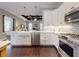 Well-lit kitchen with white cabinets, stainless steel appliances, and dark hardwood floors at 2656 Old Smyrna Trl, New Smyrna Beach, FL 32168