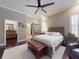Spacious main bedroom with hardwood floors, a ceiling fan, and a sliding barn door to the bathroom at 2656 Old Smyrna Trl, New Smyrna Beach, FL 32168