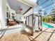 Covered patio with an outdoor shower and brick pavers overlooking the screened in pool area at 2656 Old Smyrna Trl, New Smyrna Beach, FL 32168