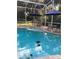 Screened-in pool area with umbrellas, table, and chairs perfect for relaxing by the turtle-filled water at 2656 Old Smyrna Trl, New Smyrna Beach, FL 32168