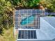 Aerial shot of screened-in kidney shaped pool with brick-paved patio and solar panel roof at 2656 Old Smyrna Trl, New Smyrna Beach, FL 32168