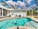 Backyard view of pool area, patio, outdoor grill and lounge chairs in a screened in enclosure at 2656 Old Smyrna Trl, New Smyrna Beach, FL 32168