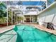 Backyard view of pool area, with an outdoor grill, chairs, pool, patio and screened in area at 2656 Old Smyrna Trl, New Smyrna Beach, FL 32168