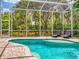 Relaxing screened pool area with brick pavers and sun loungers surrounded by lush landscaping at 2656 Old Smyrna Trl, New Smyrna Beach, FL 32168