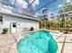 Backyard view of pool with screened enclosure, outside door, lounge chairs, and grill at 2656 Old Smyrna Trl, New Smyrna Beach, FL 32168