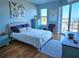 Serene bedroom featuring aqua walls, natural light, wood floors, and balcony access at 2801 S Ridgewood Ave # 512, South Daytona, FL 32119