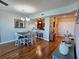 Open dining area with wood floors and a view into the kitchen area with stainless steel appliances at 2801 S Ridgewood Ave # 512, South Daytona, FL 32119