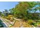 Lush backyard garden with stone paths and various potted plants and trees at 2914 Sabal Palm Dr, Edgewater, FL 32141