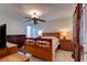 Bedroom with wooden bed frame, ceiling fan, side tables with lamps and tile flooring at 2914 Sabal Palm Dr, Edgewater, FL 32141