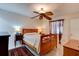Bedroom with wooden bed frame, ceiling fan, side tables with lamps, tile flooring and rug at 2914 Sabal Palm Dr, Edgewater, FL 32141