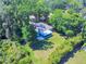 Aerial view of a charming single-story home surrounded by lush trees on a well-maintained lawn at 3013 Lime Tree Dr, Edgewater, FL 32141
