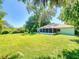 The lush backyard featuring a screened porch and manicured lawn, ideal for outdoor enjoyment and relaxation at 3013 Lime Tree Dr, Edgewater, FL 32141