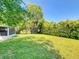 Expansive backyard features lush green grass and mature trees, perfect for outdoor activities and relaxation at 3013 Lime Tree Dr, Edgewater, FL 32141