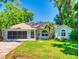 Charming home with manicured lawn, complemented by lush landscaping, an American flag and a screened garage at 3013 Lime Tree Dr, Edgewater, FL 32141