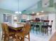 Kitchen with white cabinets, bar stool seating, stainless appliances, and dining area at 3013 Lime Tree Dr, Edgewater, FL 32141