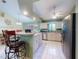 Bright kitchen featuring tile floors, stainless steel appliances, light wood cabinetry, and a granite countertop breakfast bar at 3013 Lime Tree Dr, Edgewater, FL 32141