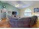 Inviting living room featuring a large, curved sectional sofa, hardwood floors, and a high, vaulted ceiling at 3013 Lime Tree Dr, Edgewater, FL 32141