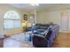Cozy living room with hardwood floors, a large window, a sectional sofa, and a glass coffee table at 3013 Lime Tree Dr, Edgewater, FL 32141