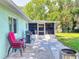 Outdoor patio area featuring a screened-in porch, grill, and relaxing seating area at 3013 Lime Tree Dr, Edgewater, FL 32141