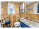 Wood paneled half-bathroom features a sink and toilet, with a seaside decor at 3016 Mango Tree Dr, Edgewater, FL 32141