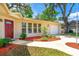 Inviting home exterior featuring a red door, manicured landscaping, and an attached garage at 3016 Mango Tree Dr, Edgewater, FL 32141