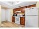 Bright kitchen with white appliances, wood cabinets, and wood look floors at 3016 Mango Tree Dr, Edgewater, FL 32141