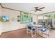 Enclosed lanai with plenty of seating, a ceiling fan, TV, and a view of the back yard at 3016 Mango Tree Dr, Edgewater, FL 32141