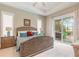 Cozy bedroom features a tray ceiling, ensuite bathroom access, and sliding doors leading to the lanai at 3219 Modena Way, New Smyrna Beach, FL 32168