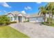Charming exterior with a three car garage, stone accents, lush landscaping, and inviting curb appeal at 3219 Modena Way, New Smyrna Beach, FL 32168