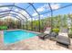 Enjoy the serene ambiance of this pool area with lounge chairs, lush greenery, and screened-in enclosure at 3219 Modena Way, New Smyrna Beach, FL 32168