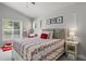 Bright bedroom featuring a comfortable bed, a nightstand, and large windows that let in natural light at 3349 Glenshane Way, Ormond Beach, FL 32174