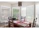 Cozy dining room featuring a wood table with seating for four, complemented by plantation shutters for ample natural light at 3349 Glenshane Way, Ormond Beach, FL 32174
