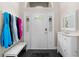 Bright entryway with white accents, a storage cabinet, bench seating, and decorative lighting at 3349 Glenshane Way, Ormond Beach, FL 32174