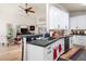 Open-concept space showcasing kitchen with breakfast bar and adjacent living area with ceiling fan at 3349 Glenshane Way, Ormond Beach, FL 32174