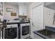 Laundry room with modern appliances, utility sink and white shaker cabinets at 3349 Glenshane Way, Ormond Beach, FL 32174