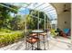 Relax on the screened patio with views of the trees and outdoor barstool set at 3349 Glenshane Way, Ormond Beach, FL 32174