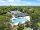 Aerial view of pool, tennis courts, and clubhouse surrounded by lush trees at 3349 Glenshane Way, Ormond Beach, FL 32174