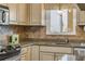 Bright kitchen with stainless steel appliances, stone countertops, tile backsplash, and view from the window at 3606 S Peninsula Dr # 509, Port Orange, FL 32127