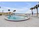 Relaxing community pool overlooking the waterfront with lounge chairs and a gazebo at 3606 S Peninsula Dr # 509, Port Orange, FL 32127
