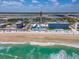 Beachfront view highlighting the condominium building, the beach, and the coastline at 3606 S Peninsula Dr # 703, Port Orange, FL 32127