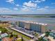 A wide aerial shot showing the Admiralty Club, located right on the water with parking and surrounding landscaping at 3606 S Peninsula Dr # 703, Port Orange, FL 32127