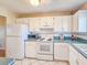 Bright kitchen featuring white cabinets, appliances, and tiled floors at 3606 S Peninsula Dr # 703, Port Orange, FL 32127