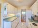 Galley kitchen features white cabinets and appliances with a tiled floor at 3606 S Peninsula Dr # 703, Port Orange, FL 32127