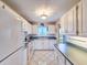 Well-lit kitchen with white cabinetry, white appliances, and views from the sink window at 3606 S Peninsula Dr # 703, Port Orange, FL 32127