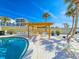 Inviting pool area with a pergola, lounge chairs and tropical palm trees at 3606 S Peninsula Dr # 703, Port Orange, FL 32127