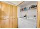 A laundry room with modern appliances and wood folding closet doors at 402 Bouchelle Dr # 206, New Smyrna Beach, FL 32169