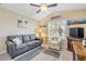 Cozy living room with a gray sofa, ceiling fan, and coastal-themed artwork at 402 Bouchelle Dr # 206, New Smyrna Beach, FL 32169