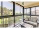 Relaxing screened-in patio features comfortable seating and views of the lush surroundings at 402 Bouchelle Dr # 206, New Smyrna Beach, FL 32169