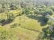 Expansive grassy field surrounded by lush trees and natural beauty from an aerial view at 416 Western Rd, New Smyrna Beach, FL 32168