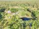 Stunning aerial view showcasing a property with a home, pond, and mature trees at 416 Western Rd, New Smyrna Beach, FL 32168